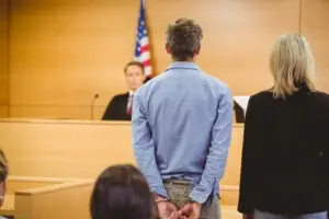 a male client with a female attorney facing the judge at an arraignment