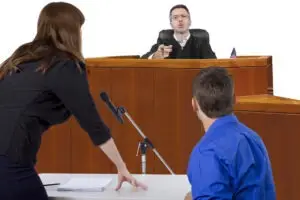 a female attorney speaking on behalf of a male defendant in a courtroom during a preliminary hearing