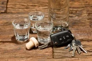 Keys sit next to shot glasses on a table in Los Angeles, CA. A DUI lawyer can advise you how to disclose a drunk driving conviction when applying for a job.