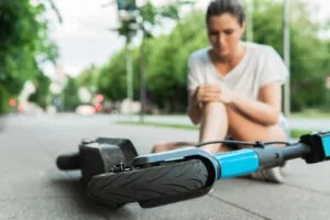 Young woman suffering scooter accident on a city street. Contact a personal injury lawyer after an accident in Lake Forest