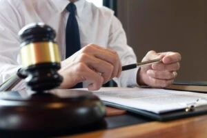 A professional attorney sitting at their desk demonstrating ten qualities of a great criminal defense lawyer to their client.