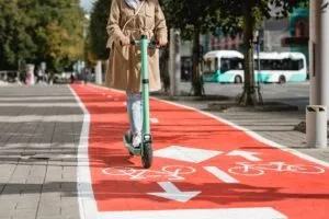 A woman uses a scooter while using the crosswalk. A lawyer can help you understand when you can drive a scooter after a DUI charge on your record.