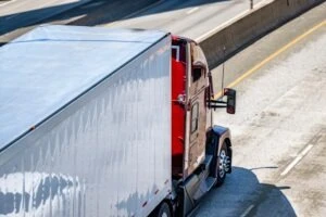 A red truck is driving on a divided highway. Talk to an experienced Los Angeles lawyer to learn when a roadway is considered a divided highway.