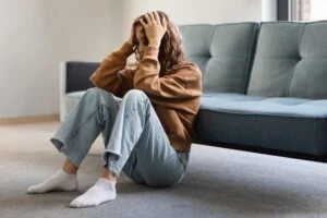 A young woman sits on the ground while struggling with mental health and a 5150 hold in California.