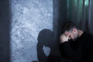 A man sits alone, holding his head, while on a psychiatric hold in California. The difference between a 1799 hold and a 5150 hold is the length of time a person can be kept in a hospital and the reasons for their detention. A 1799 hold lasts up to 24 hours, while a 5150 hold can extend up to 72 hours.