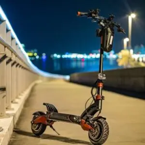 An electric scooter parked on a city bridge sidewalk at night