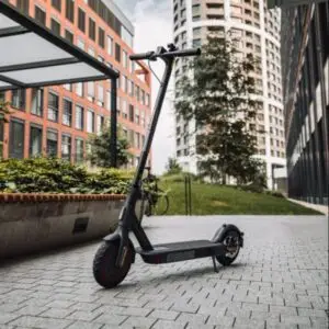 A modern electric scooter parked on a paved walkway between high-rise buildings