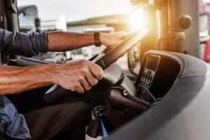 A commercial driver sits behind the wheel of his truck