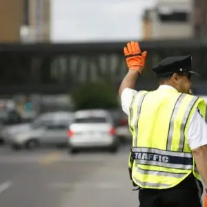 A police officer holds his hand up to signal a stop