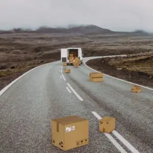 Boxes liter the road after falling out of a truck