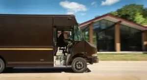 A brown delivery truck speeding down a road