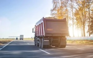 A construction truck carries sand on a highway.