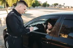 A cop writing a female driver a ticket.