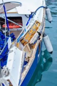 A view of the damaged side of a boat after an accident.
