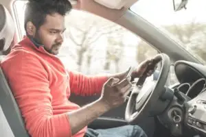 A man uses his cell phone while driving.