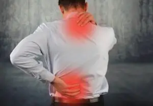 A man rubbing sore spots on his neck and back.