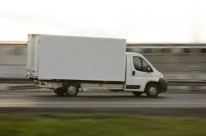 A moving van speeding on a highway.