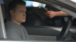 A nervous man waits for a ticket from a police officer.