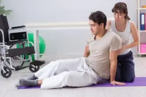 A physical therapist helping a man with a back injury