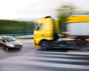 A truck speeds at a car