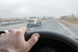 The view from a steering wheel of a car changing lanes.