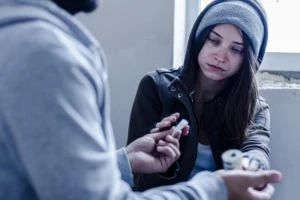 A woman exchanging money for drugs.