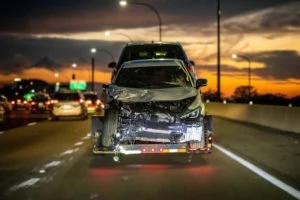 A damaged car being towed on the highway.