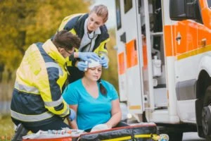 EMTs bandaging an accident victim’s head.