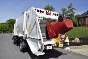 A garbage truck stopped on a road.