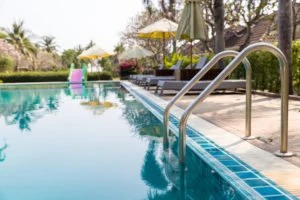 An in-ground swimming pool surrounded by chairs.