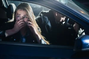 An injured passenger makes a call from her phone after an accident.