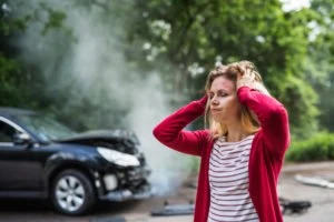 An injured woman holding her head after a car accident.