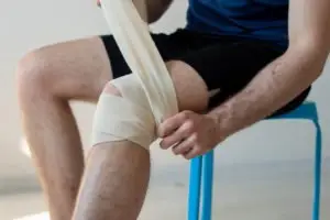 A man bandaging his knee.