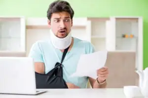 A man in a neck brace looks shocked at his medical bills.