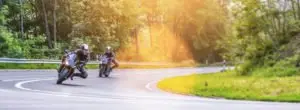 Motorcyclists making a turn and crossing over to the wrong side of the road.