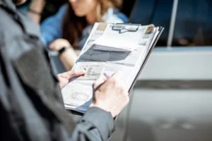 A police officer writing a ticket for a driver.