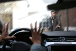 A shocked pedestrian about to be struck by a car.