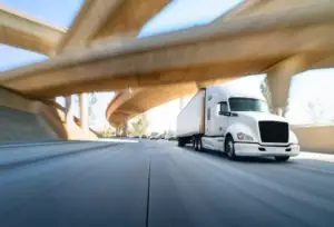 A speeding truck, driving on a highway