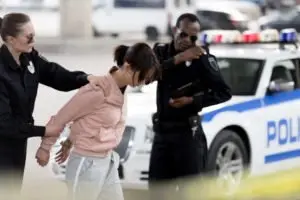 A woman arrest by a female officer.