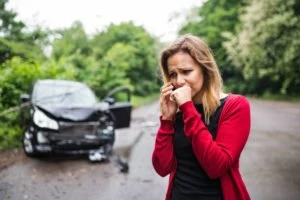 A woman on her phone after an accident.