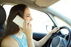 A woman talking on her phone while driving.