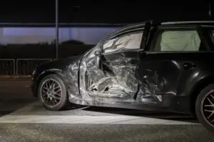 smashed-up black car after a t-bone accident