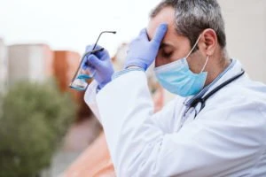 stressed doctor rubbing his forehead