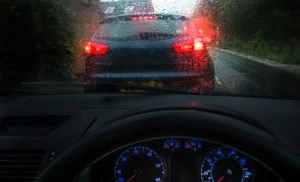 car tailgating another car in the rain