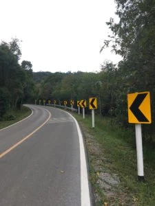 curved road with left-pointing arrows