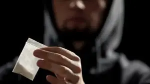 drug dealer holding a cocaine package