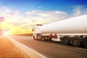 fuel truck driving down the road at sunset