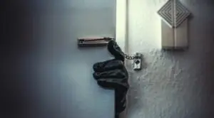 gloved hand reaching around a door