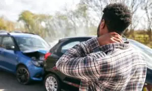 guy rubbing his neck after an accident