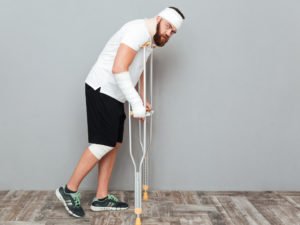 man with crutches, bandages, and cast